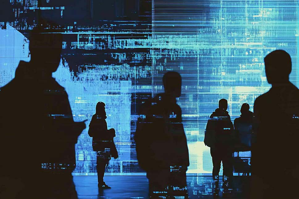Silhouetten von Menschen vor einem digitalen, blau gefärbten Daten-Display.